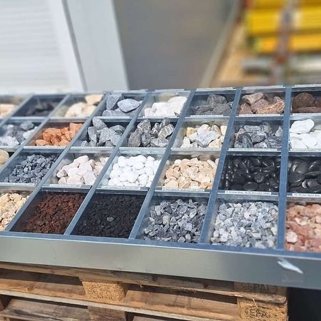 Steintisch mit vielen verschiedenfarbigen, sortierten Steinen